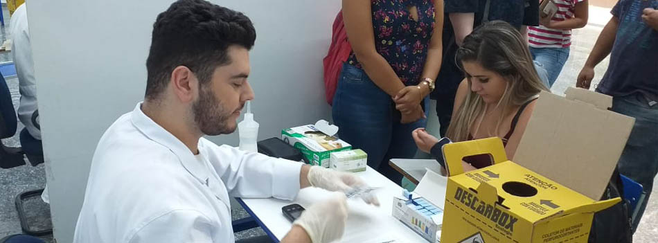 Aluno realizando procedimento durante a Campanha de Diabetes