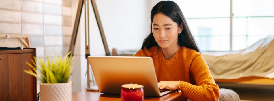 Mulher usando um notebook sentada em uma sala