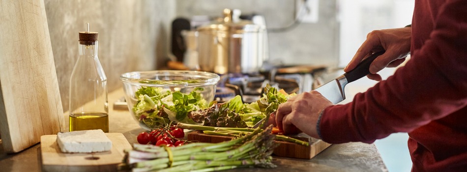 Pessoa cortando alimentos em uma cozinha