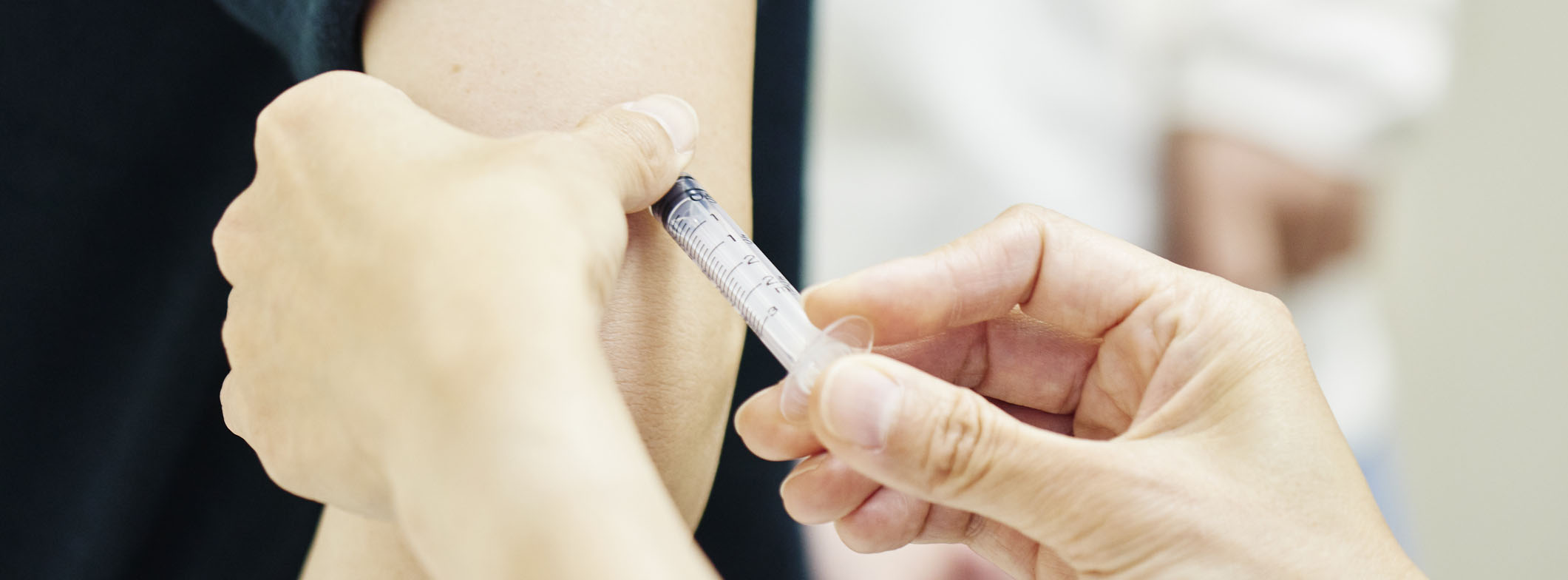 Female doctor giving a vaccination shot to a young woman